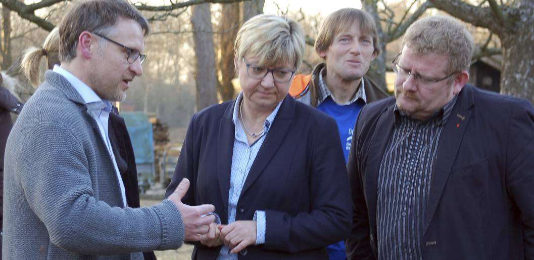 Markus Steinbach (links) erläutert Frauke Heiligenstadt und Bernd Wölbern Besonderheiten im Garten der Einrichtung.