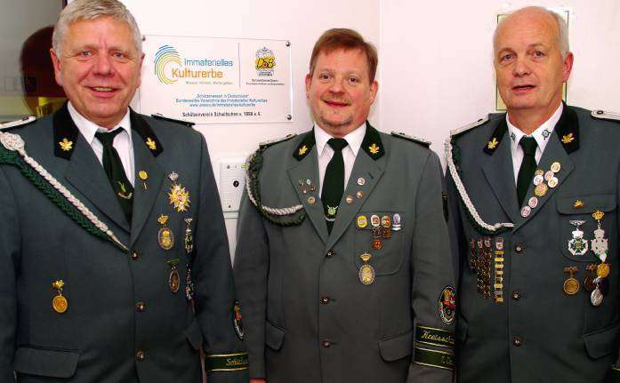 Schießsportleiter Ulrich Röhrs (von links), Vorsitzender Hans Joachim Rodewald und sein Stellvertreter Fritz-Jürgen Gerke freuen sich über die neue Ehrentafel für den Schützenverein.