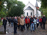 Ortsbürgermeister Gerhard Behrens (links mit Schirm) führte die Gruppe aus Teilnehmern der Messe Intergeo in Bremen durch Fischerhude Foto: Mertins